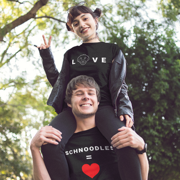 Woman sitting on man's shoulders posing for a photo, both wearing T-Shirts from the 